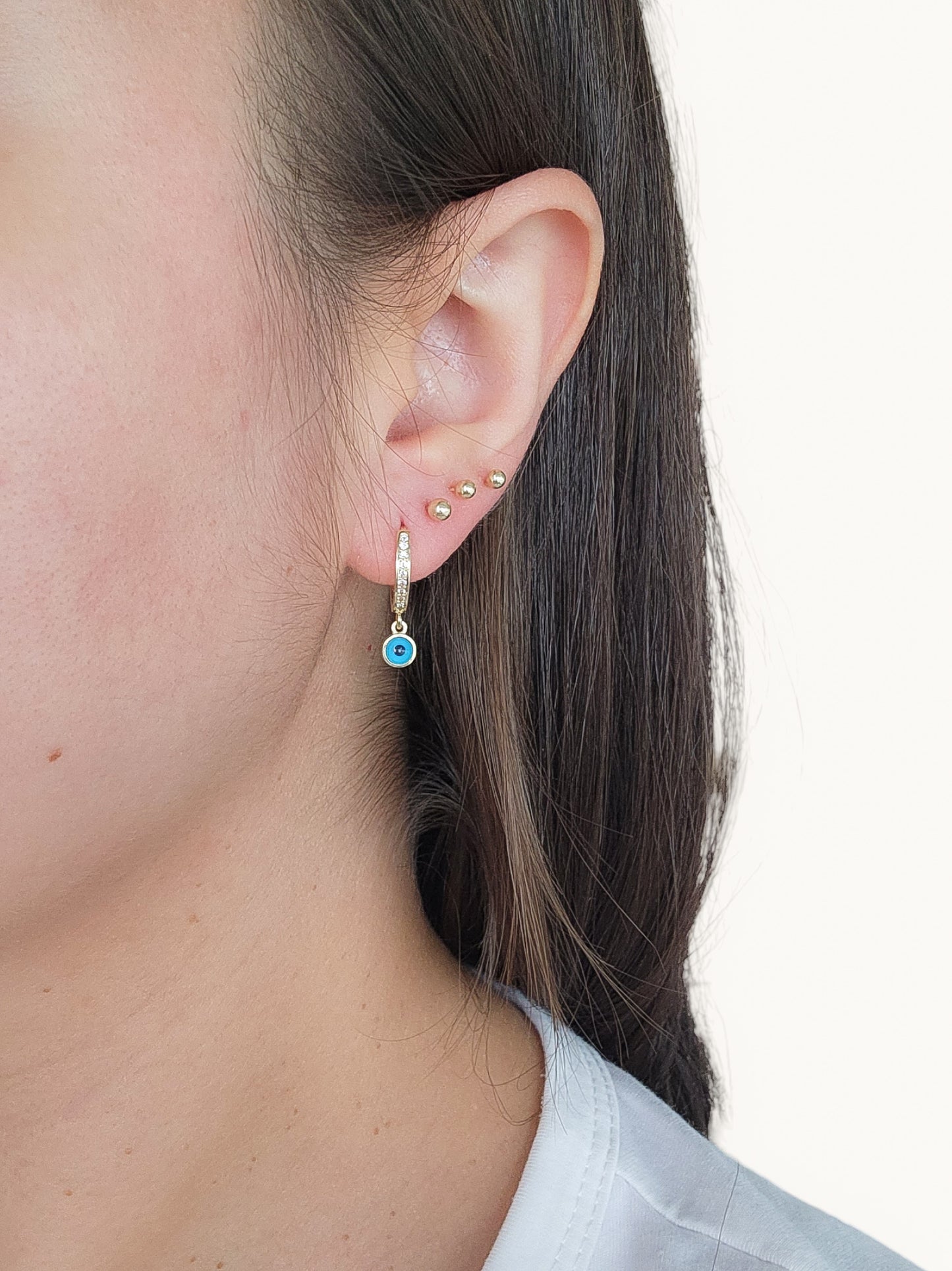 Huggies de circonias blancas y dije colgante ojo turco azul