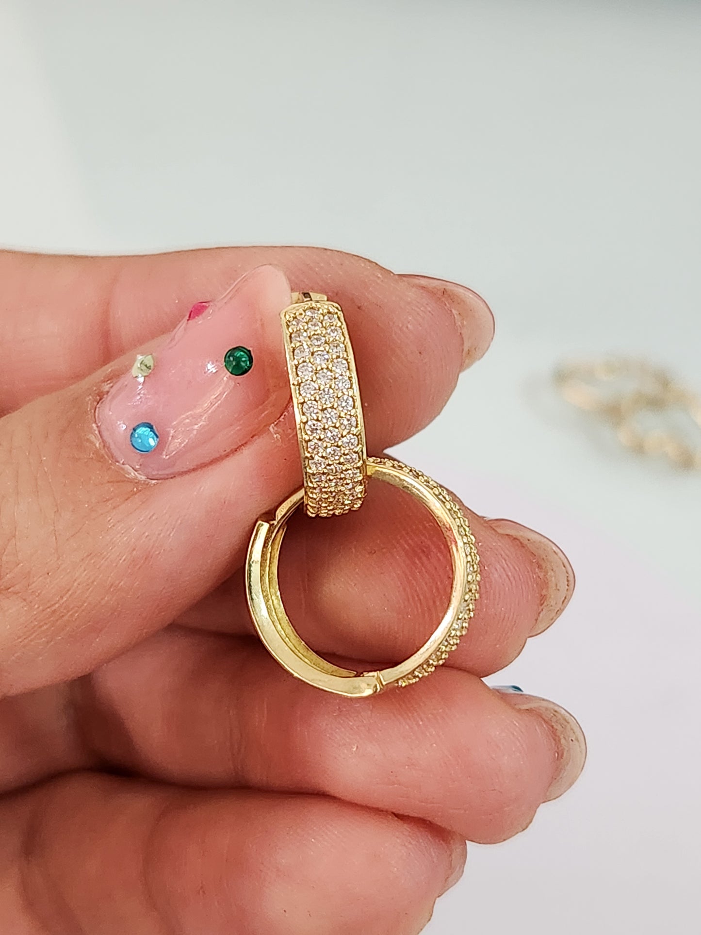 Huggies triple con piedras blancas oro 10k