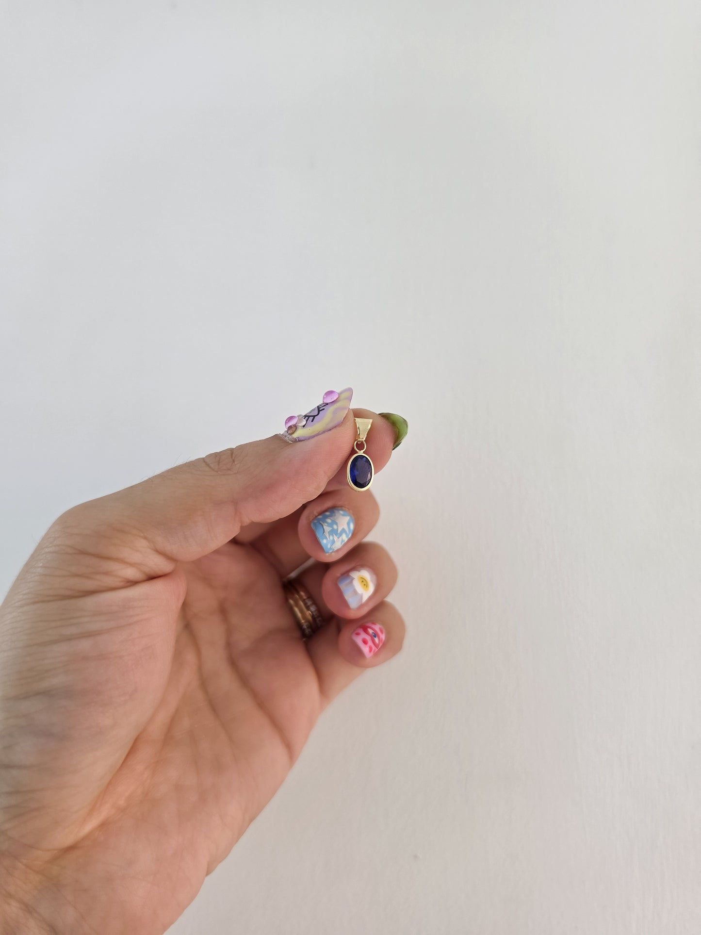 Dije corte oval con zirconia azul oro 10k