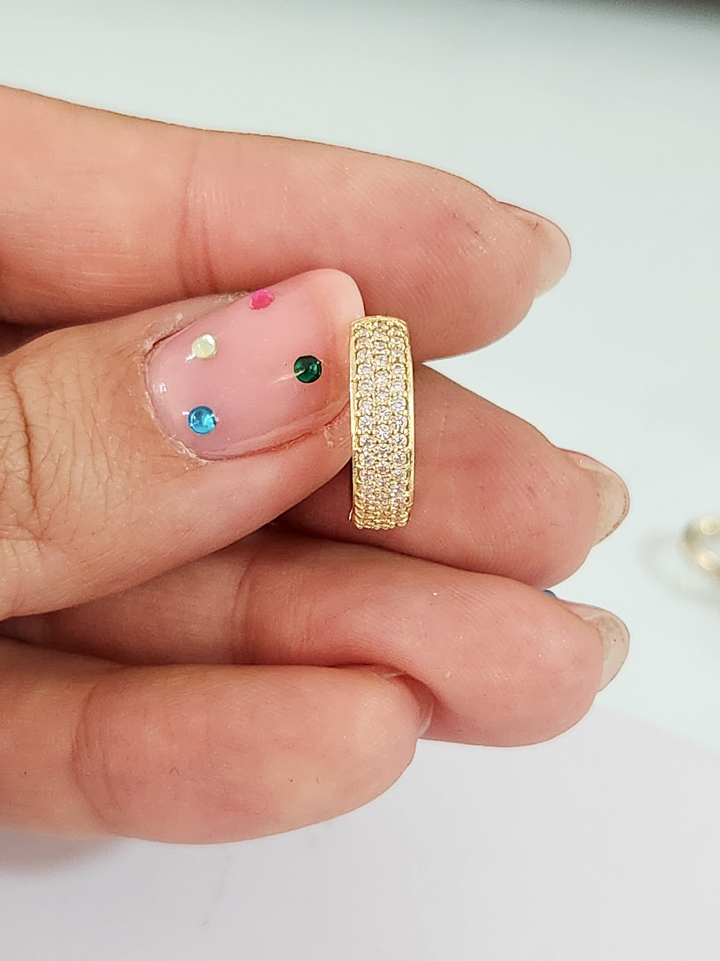 Huggies triple con piedras blancas oro 10k